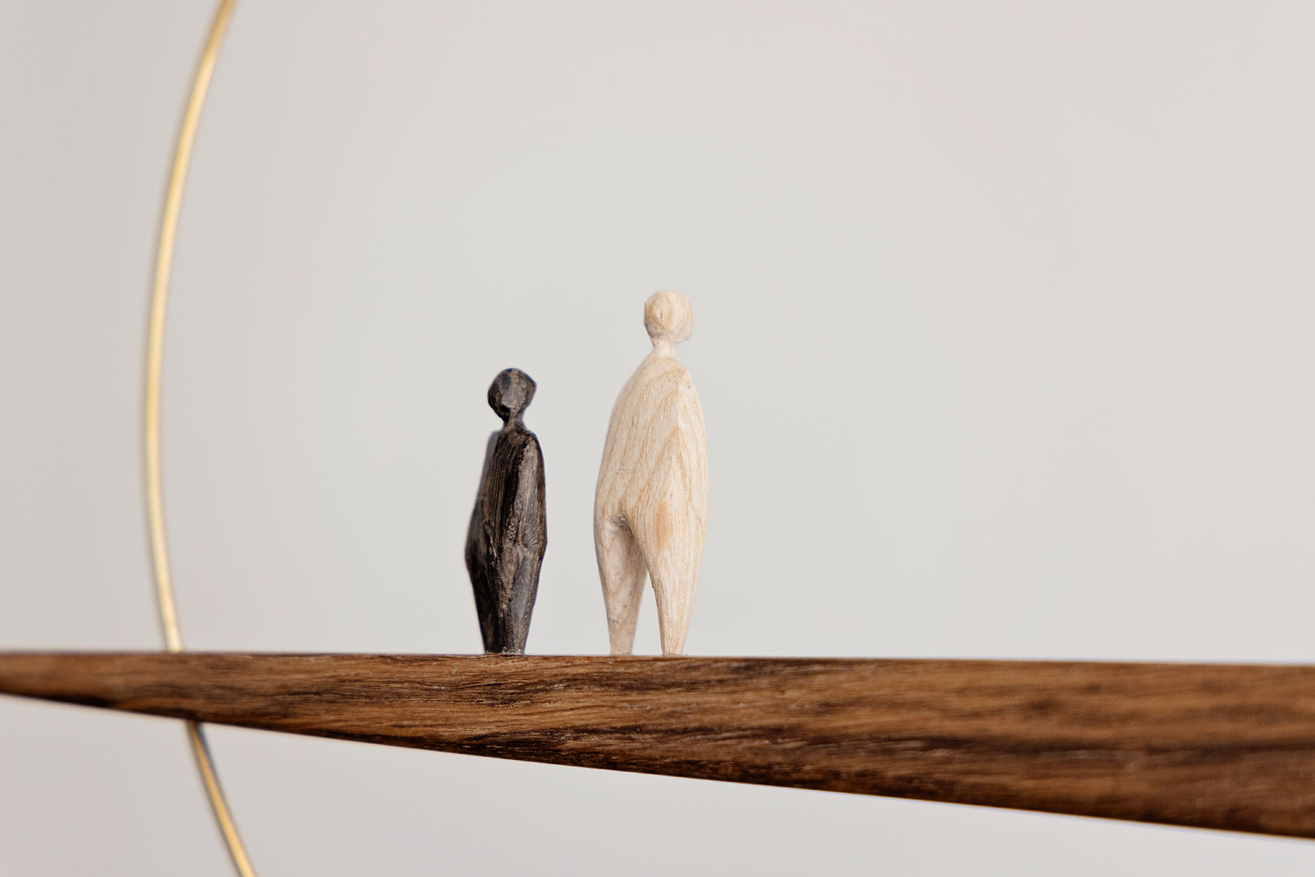 A modern sculptural mobile by Studio Logan Howes featuring two sculpted wooden figures made from reclaimed wood.
